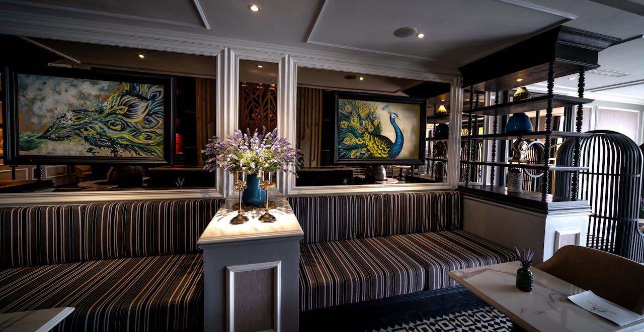 Luxurious hotel lobby featuring peacock paintings and ornate decor for a stylish ambiance.